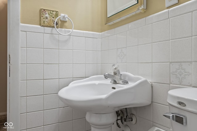 bathroom featuring tile walls and toilet