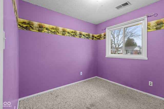 carpeted spare room with a textured ceiling