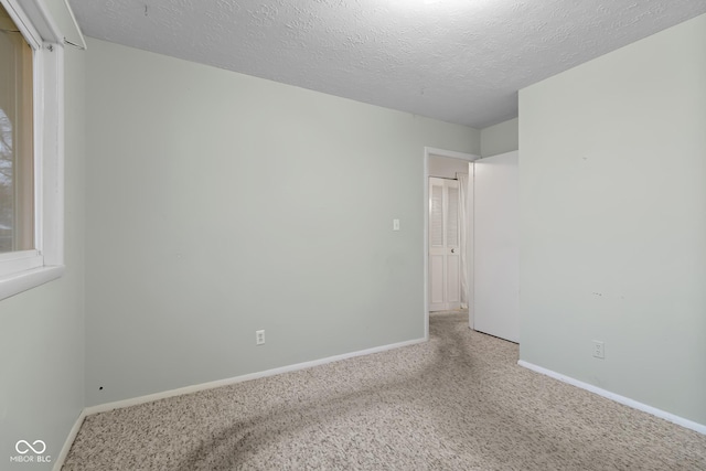 unfurnished room featuring a textured ceiling and carpet flooring