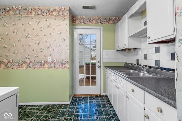 kitchen featuring sink, backsplash, white cabinets, and a textured ceiling