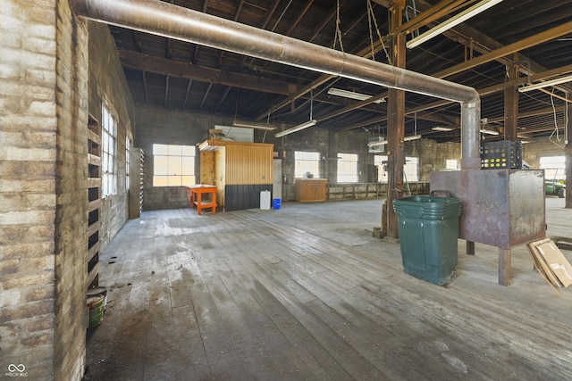 miscellaneous room with hardwood / wood-style flooring, a healthy amount of sunlight, and a towering ceiling