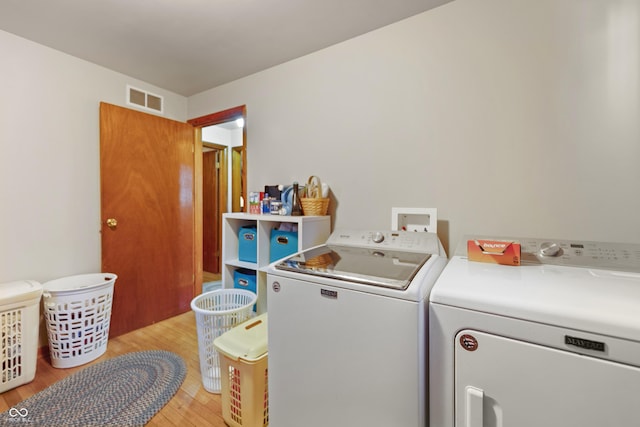 washroom featuring washing machine and dryer and light wood-type flooring