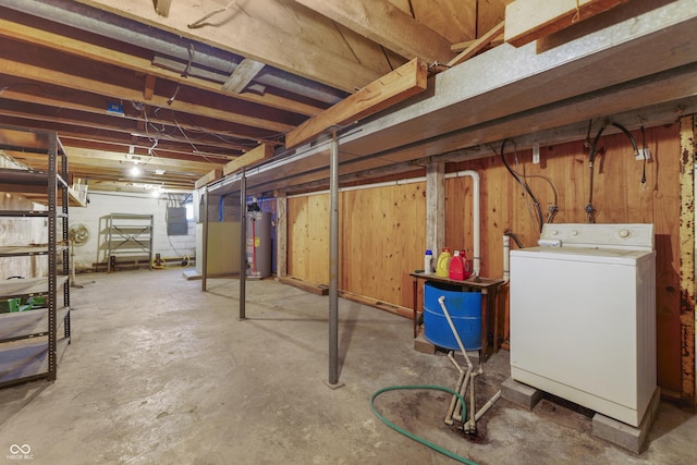 basement featuring wooden walls, washer / clothes dryer, electric panel, and gas water heater