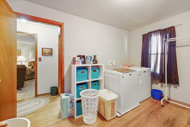 laundry area with washer and dryer and light hardwood / wood-style floors