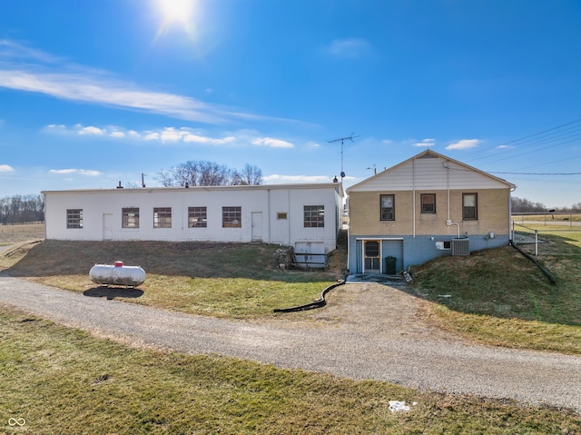 view of front of home featuring a front yard and central air condition unit