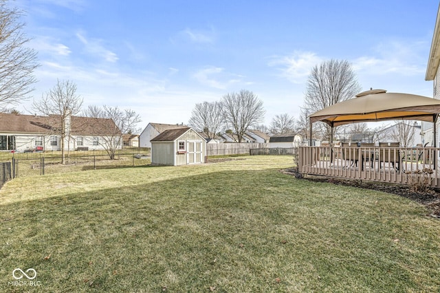 view of yard featuring a gazebo, a wooden deck, and a storage shed