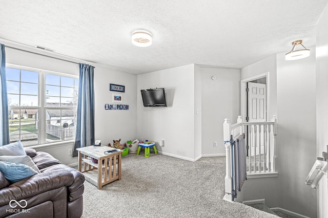 playroom with light colored carpet and a textured ceiling