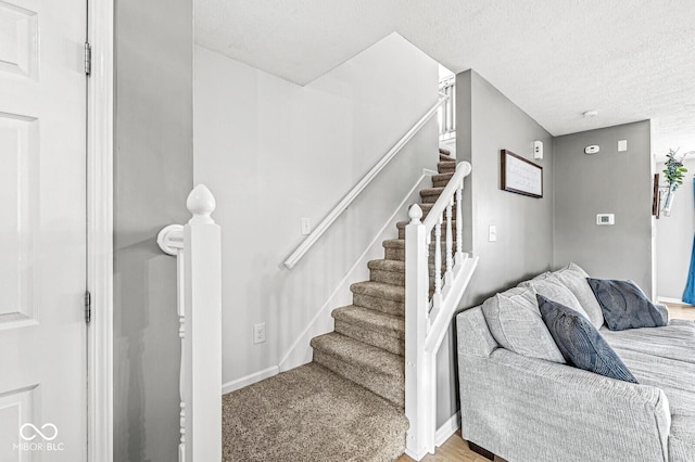 stairway featuring a textured ceiling