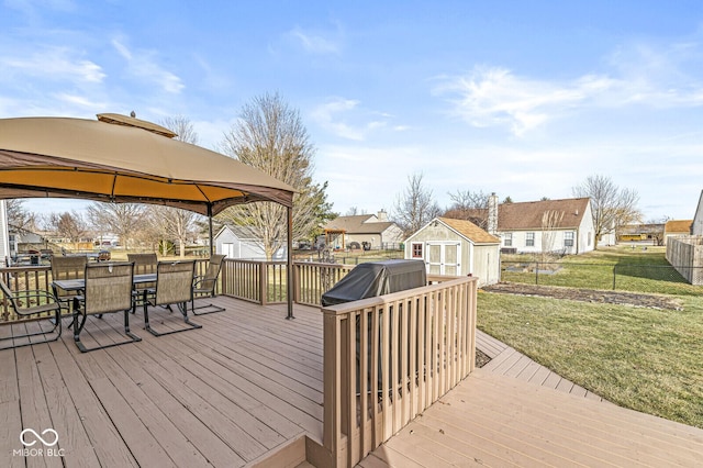 deck with a gazebo, a yard, and a storage shed