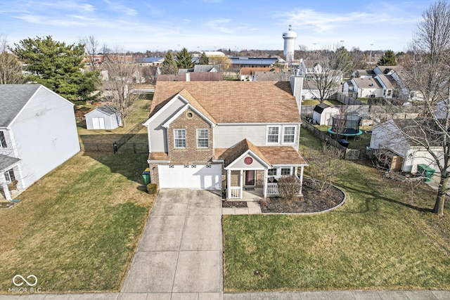 view of front of property featuring a garage, a front lawn, and covered porch