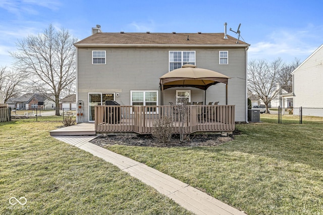 back of property featuring a wooden deck, a gazebo, and a yard