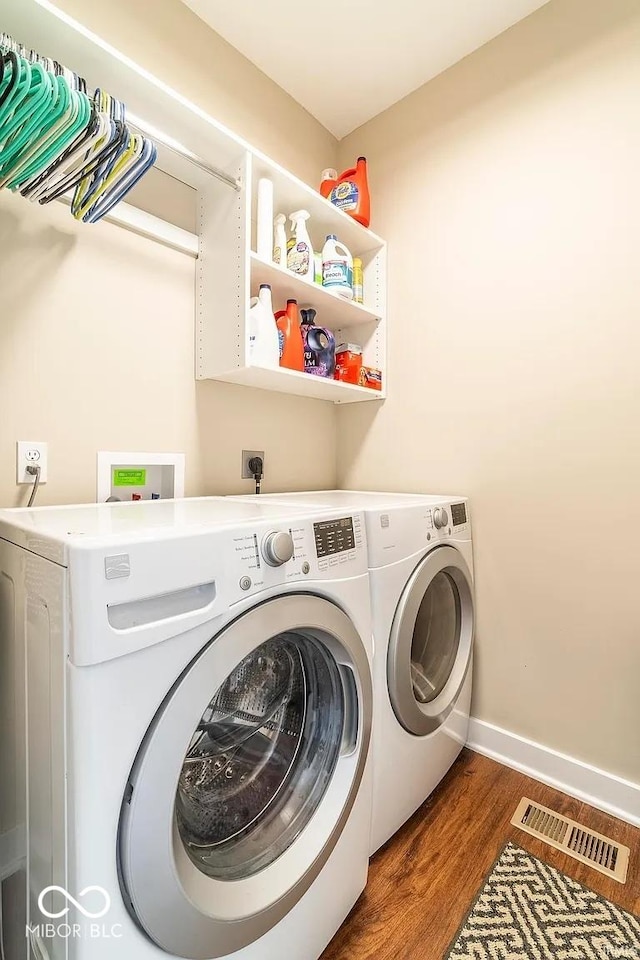 laundry area featuring separate washer and dryer and dark wood-type flooring