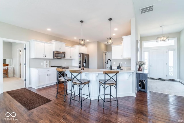 kitchen featuring stainless steel appliances, pendant lighting, and white cabinets