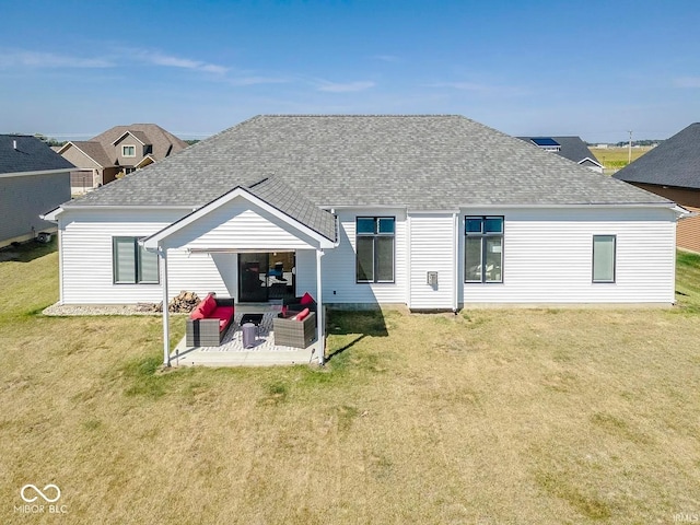 rear view of property featuring outdoor lounge area, a patio area, and a lawn