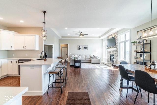 kitchen with hanging light fixtures, white cabinetry, dark wood-type flooring, and a kitchen breakfast bar