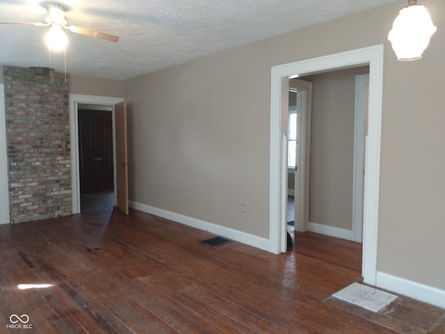 unfurnished room featuring dark hardwood / wood-style flooring, ceiling fan, and a textured ceiling