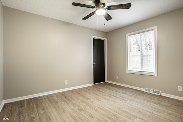 spare room featuring ceiling fan, light hardwood / wood-style floors, and a textured ceiling