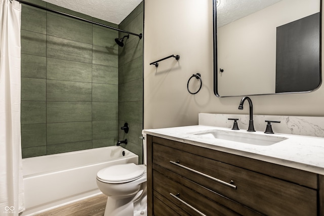 full bathroom featuring hardwood / wood-style flooring, vanity, shower / bath combination with curtain, a textured ceiling, and toilet