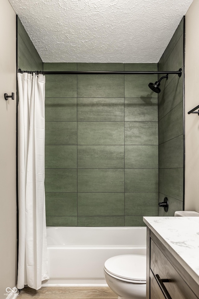 full bathroom featuring shower / bathtub combination with curtain, hardwood / wood-style floors, vanity, a textured ceiling, and toilet