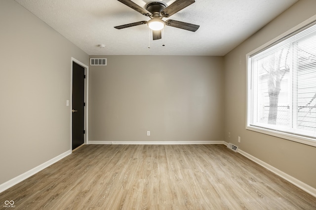 unfurnished room with ceiling fan, a textured ceiling, and light wood-type flooring