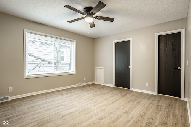 unfurnished bedroom with ceiling fan, light hardwood / wood-style floors, and a textured ceiling