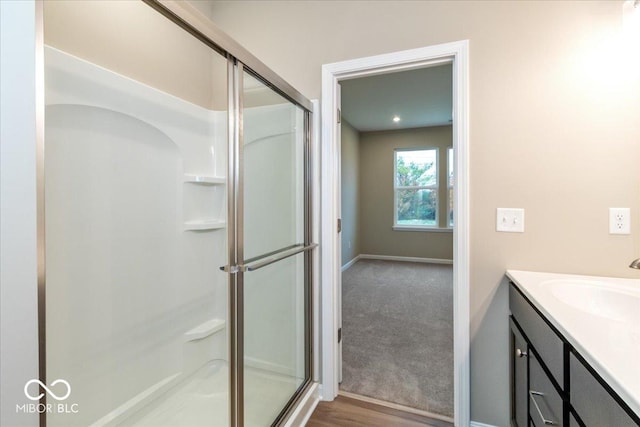 bathroom with vanity, a shower with door, and hardwood / wood-style floors