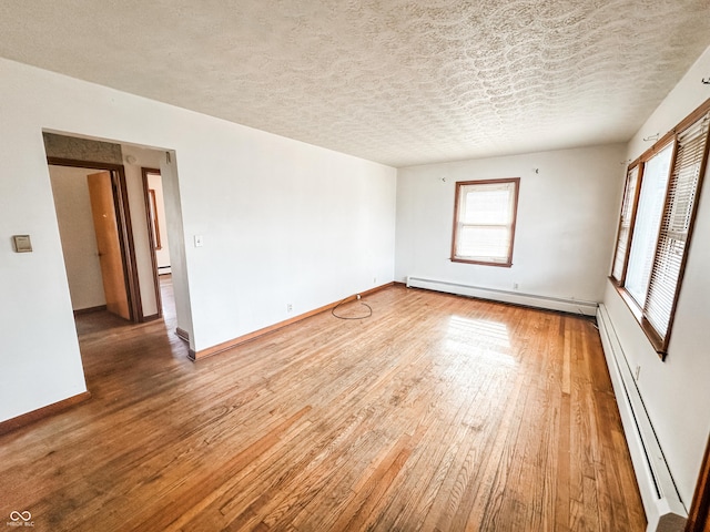 unfurnished room with hardwood / wood-style flooring, a baseboard radiator, and a textured ceiling