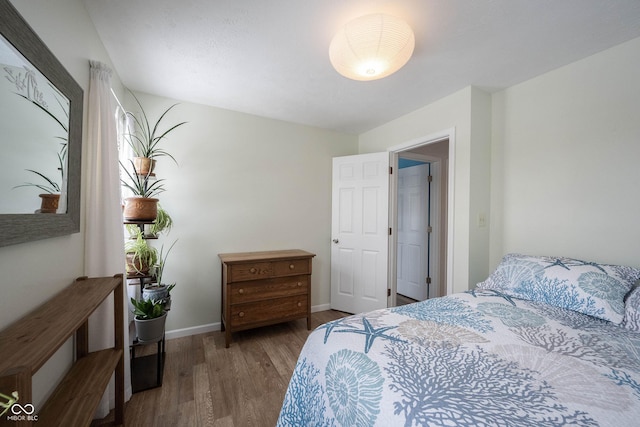 bedroom with baseboards and wood finished floors