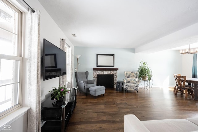 living room with dark wood-style flooring, a fireplace, and a wealth of natural light