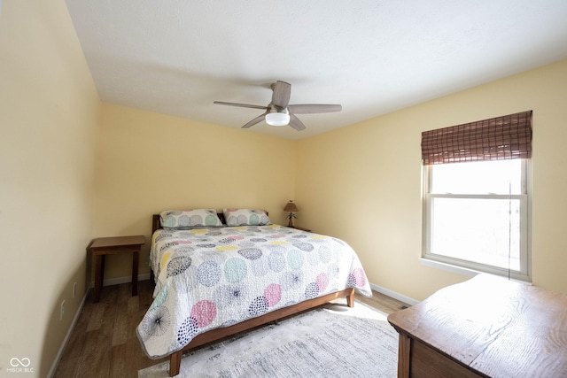 bedroom featuring ceiling fan, baseboards, and wood finished floors