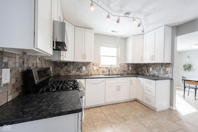 kitchen featuring dark countertops, a sink, white cabinetry, and dishwasher