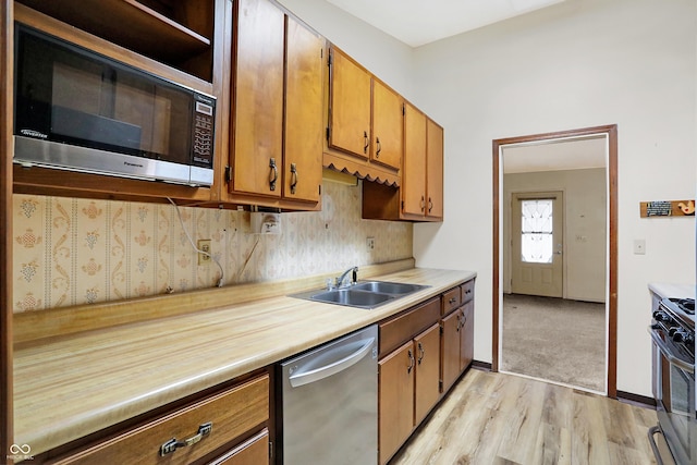 kitchen featuring tasteful backsplash, sink, stainless steel appliances, and light hardwood / wood-style floors