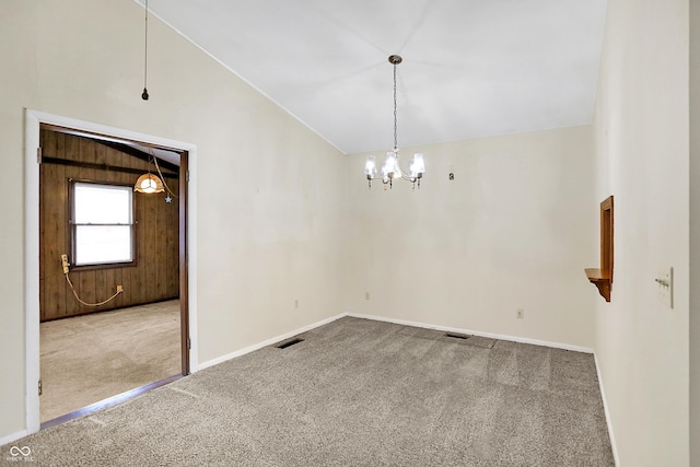 carpeted spare room with vaulted ceiling and a notable chandelier