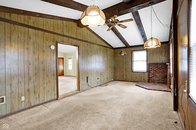 unfurnished room featuring lofted ceiling with beams, light carpet, ceiling fan, and wood walls