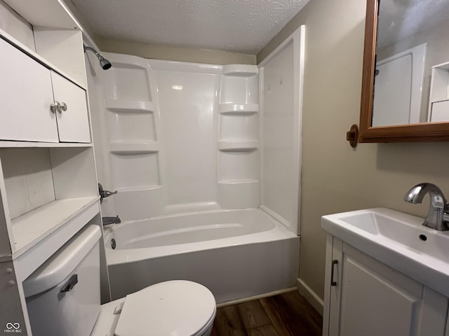 full bathroom featuring hardwood / wood-style flooring, vanity, shower / bathing tub combination, a textured ceiling, and toilet