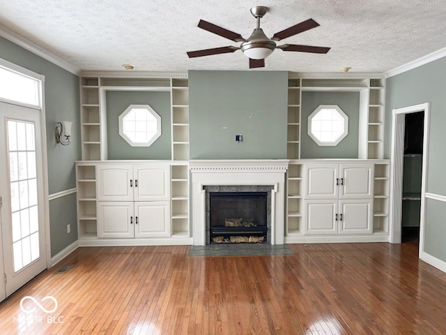 unfurnished living room with crown molding, wood-type flooring, a fireplace, and a textured ceiling