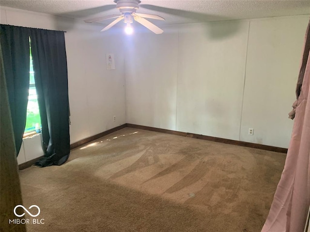 carpeted empty room featuring ceiling fan and a textured ceiling