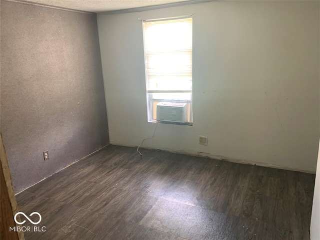 spare room featuring cooling unit and dark hardwood / wood-style flooring