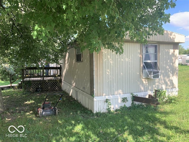 view of side of property with a wooden deck and a yard