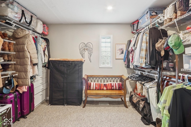 walk in closet featuring light colored carpet