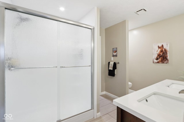 bathroom with vanity, toilet, and a shower with door