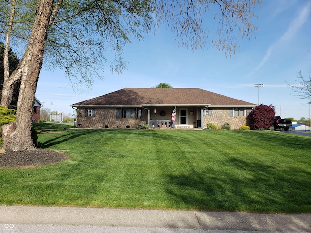 ranch-style house featuring a porch and a front lawn