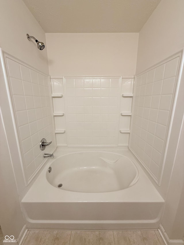 bathroom featuring tile patterned floors, shower / washtub combination, and a textured ceiling