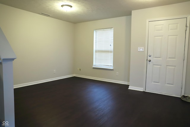 entryway featuring dark wood-type flooring and a textured ceiling