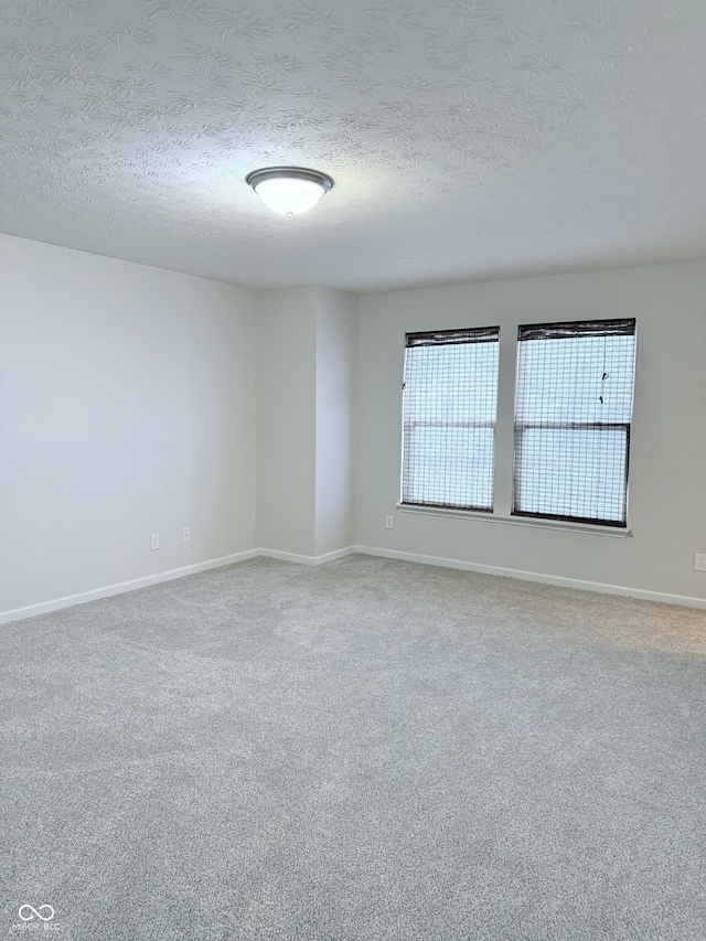 unfurnished room featuring a textured ceiling and carpet flooring