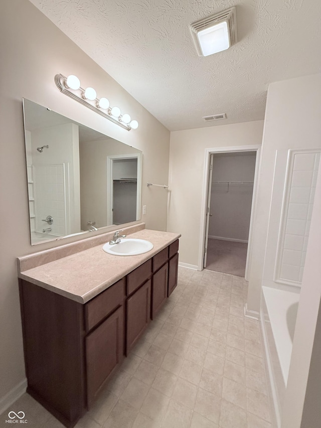 bathroom featuring vanity, shower / washtub combination, and a textured ceiling