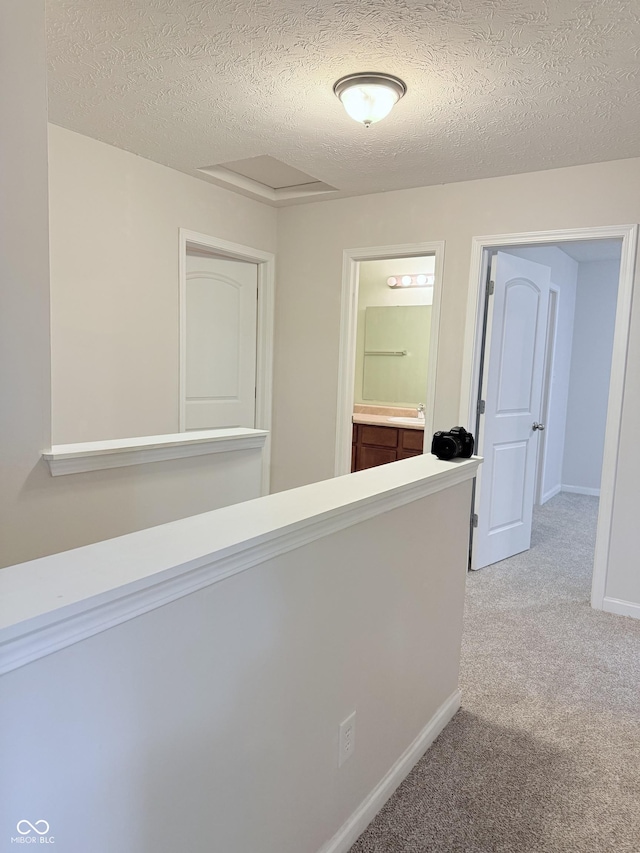 corridor featuring carpet floors and a textured ceiling