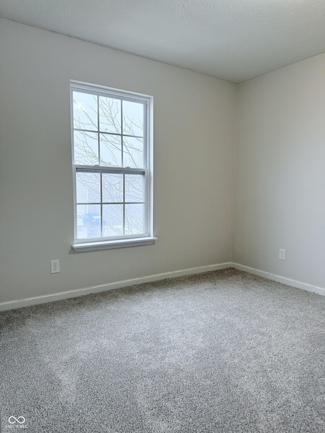 carpeted empty room with a textured ceiling