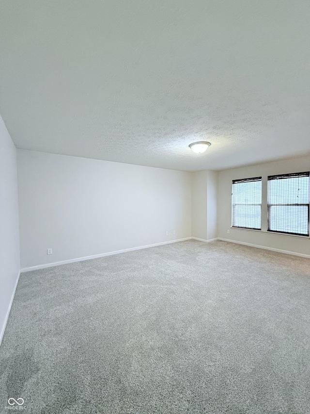 unfurnished room featuring carpet flooring and a textured ceiling