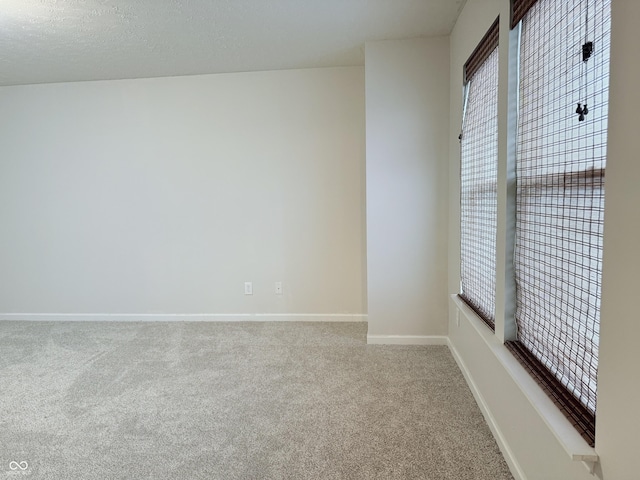 unfurnished room featuring carpet flooring and a textured ceiling